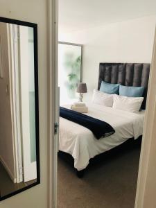 um quarto com uma cama grande e um espelho em Uptown Accommodations em Windhoek