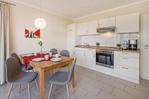 a kitchen and dining room with a wooden table and chairs at Ferienhaus Sonne 6c in Korswandt