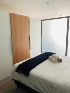 um quarto com uma cama com duas toalhas em Uptown Accommodations em Windhoek