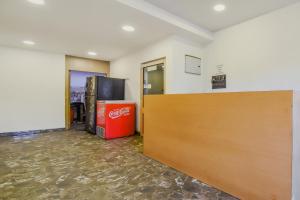 uma sala vazia com uma porta e uma máquina de coca em Super OYO Krishna Guest House em Calcutá