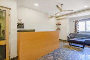- une porte coulissante dans une chambre avec un canapé dans l'établissement Super OYO Krishna Guest House, à Kolkata