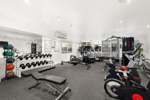 a gym with several treadmills and exercise bikes at Melbourne City Suites in Melbourne