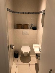 małą łazienkę z toaletą i umywalką w obiekcie Volledig gerenoveerd 2 slaapkamer appartement, 250 m van het strand w mieście Middelkerke