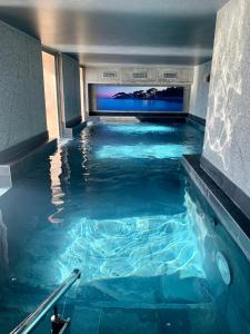 una piscina coperta con acqua blu in un edificio di Splendid Hôtel & Spa a Bandol