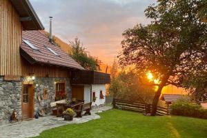 a house with a bench and a tree in a yard at Traditional Slovenian house in Vransko