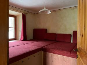 a room with a red couch with a window at Traditional Slovenian house in Vransko