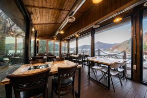 a restaurant with tables and chairs and large windows at Hotel Haus in Gapyeong