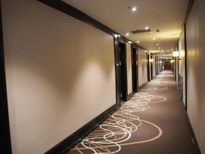 einen Flur mit einem langen Korridor mit Lichtern auf dem Boden in der Unterkunft Xana Hotelle Yining Airport Road Jinwuyuan in Kipekyüzi