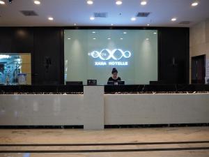 Eine Frau ist auf einem Bildschirm vor einer Bühne in der Unterkunft Xana Hotelle Yining Airport Road Jinwuyuan in Kipekyüzi