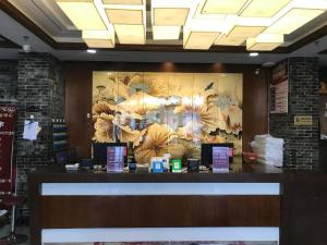 a restaurant counter with a large painting of flowers at PAI Hotels Jinzhou Yi County Railway Station in Jinzhou +2 photos