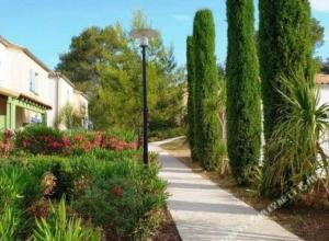 uma luz de rua ao lado de um jardim com árvores em Maison calme + piscine + pinède + parking em Castries