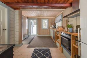 a kitchen with wooden ceilings and a hallway at Koselig hytte 10 minutter fra Lillehammer sentrum in Lillehammer