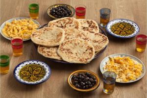 a wooden table topped with plates of food and drinks at Familles avec bébé in Fez
