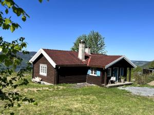 a small house with two dogs sitting outside of it at Koselig hytte 10 minutter fra Lillehammer sentrum in Lillehammer