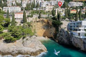 um pássaro a voar sobre uma massa de água em Villa B with Old town & sea view em Dubrovnik