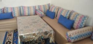 ein Sofa mit blauen Kissen im Wohnzimmer in der Unterkunft Familles avec bébé in Fès