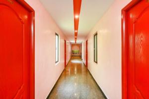 a corridor with red doors and a long hallway at OYO Gnana S.R.M Residency in Puducherry