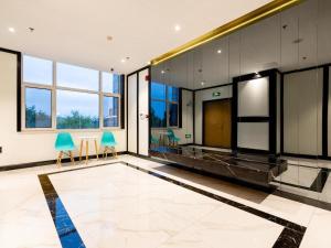 een grote kamer met een lobby met groene stoelen bij Xana Lite Tianjin Ninghe Trade Development Zone in Ninghe