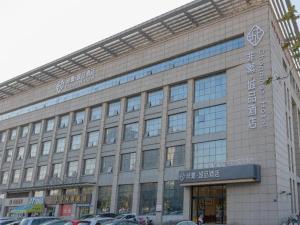 a large building with cars parked in front of it at Chonpines Hotel Jining Quanmin Fitness Plaza in Jining