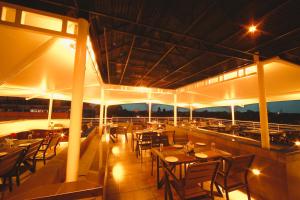 a restaurant with tables and chairs on a balcony at night at Akhil Classic in Trivandrum