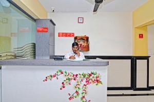 a woman sitting at a counter talking on a cell phone at Hotel O Ashwarya Service Apartment in Navi Mumbai +13 photos