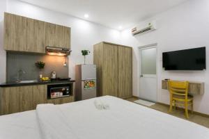 a room with a bed and a kitchen with a refrigerator at Cactusland Near Tan Son Nhat Airport in Ho Chi Minh City
