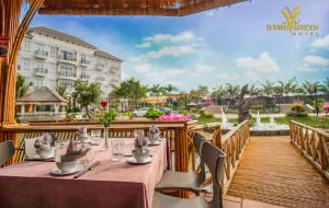 een restaurant met een tafel en stoelen op een terras bij SPRING GARDEN HOTEL LK in Long Khanh