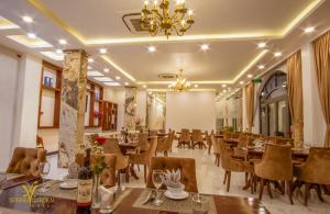 Long KhanhにあるSPRING GARDEN HOTEL LKのテーブルと椅子、シャンデリアのあるレストラン