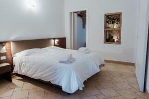 una camera da letto con un grande letto con lenzuola bianche di Hotel Alla Sosta a Rezzato