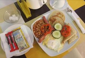 a plate of breakfast food with eggs beans and vegetables at Ayoluyem Aparthotel and Suites in Ogbodo