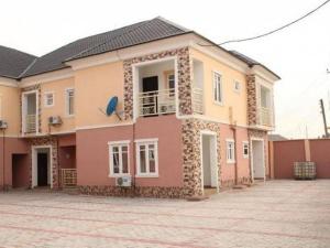 duży różowy dom z dziedzińcem przed nim w obiekcie Ayoluyem Aparthotel and Suites w mieście Ogbodo