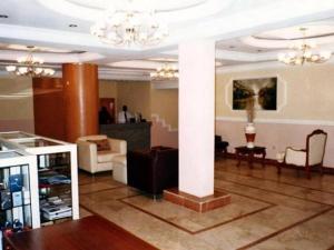 a lobby with a column and a couch and chairs at Roban Hotels Ltd in Enugu