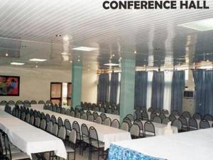 a conference hall with white tables and chairs at Roban Hotels Ltd in Enugu