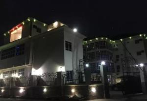 un edificio blanco con luces encendidas por la noche en Top Rate Hotel en Owerri