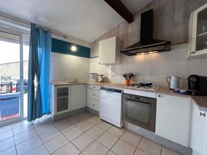 a kitchen with white appliances and a large window at LA BERGERIE DOUCEUR AUBORD in Aubord