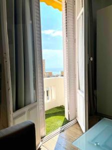 Zimmer mit offenem Fenster und Blick auf ein Gebäude in der Unterkunft Cute comfortable apartment with Monaco & sea view in Beausoleil