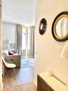 ein Wohnzimmer mit einem Sofa und einem Spiegel an der Wand in der Unterkunft Cute comfortable apartment with Monaco & sea view in Beausoleil
