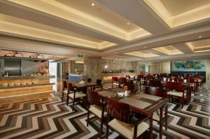 a restaurant with tables and chairs and a bar at The Hotel V Zhenjiang Jingkou in Zhenjiang