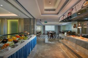 a buffet line in a hotel with food on display at The Hotel V Zhenjiang Jingkou in Zhenjiang