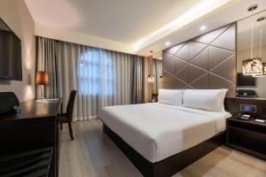 Tempat tidur dalam kamar di Orange Hotel Qingdao The Mixc