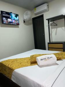 Habitación de hotel con cama con almohada en Hotel Olam Confort, en Villavicencio