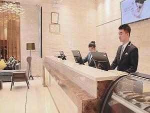 a man and a woman sitting at a counter with laptops at City Comfort Inn Chenzhou Youa International Plaza in Chenzhou