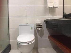 Łazienka z białą toaletą i umywalką w obiekcie Borrman Hotel Meizhou Mei County Airport w Meizhou