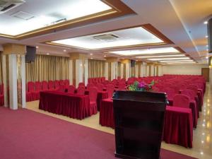 sala konferencyjna z czerwonymi krzesłami i podium w obiekcie Borrman Hotel Meizhou Mei County Airport w Meizhou