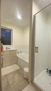 Un baño blanco con bañera y inodoro. en 3 Bedroom Home by the Reserve, en Rotorua 11 fotos más
