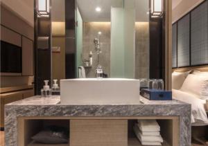 un baño con un lavabo grande en una habitación de hotel en Echarm Hotel Wuhan Tianhe Airport Outlets en Huanghualao