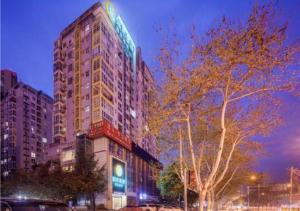 un edificio alto con un cartel en el costado en City Comfort Inn Chengdu Dongjiao Memory, en Chengdú
