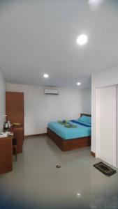 1 dormitorio con 1 cama azul en una habitación en Tanyaporn House, en Haad Rin