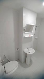 La salle de bains blanche est pourvue de toilettes et d'un lavabo. dans l'établissement Tanyaporn House, à Haad Rin