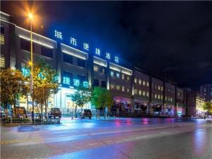 um edifício numa rua da cidade à noite em City Comfort Inn Kunming Qianxing Road Dashanghui Children's Hospital em Kunming